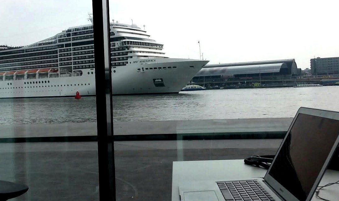 Werkplek met laptop en uitzicht over het IJ in Amsterdam